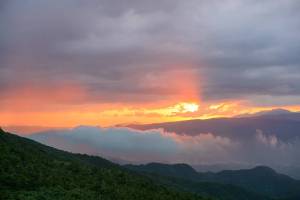 Nature\'s Spectacle: Crepuscular Rays and Shifting Clouds at the Mountain Top. The Wufenshan Weather Radar Station stands on the top of the mountain. Taiwan