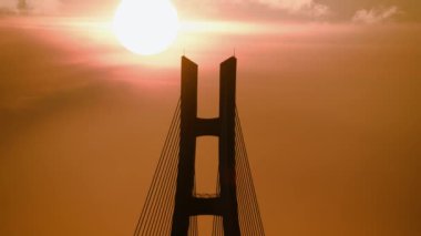 Gün batımında köprü rıhtımları ve şehir silueti. Yeni Taipei Köprüsü Tamsui Nehri boyunca uzanır. Kablolu bir köprü..