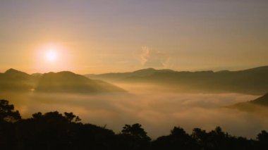 Güneşin turuncu-kırmızı parıltısı bulutların azgın denizini aydınlattı. Sabah erkenden çay bahçeleri, bulutlar denizi ve gün doğumu, Pinglin Bölgesi, New Taipei.