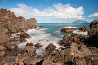 Mavi deniz ve mavi gökyüzü ve değişen beyaz bulutlar. Küçük adalar ve kayalar. Guishan Adası (Kaplumbağa Adası) Pasifik Okyanusu 'nda bir volkanik adadır. Tayvan