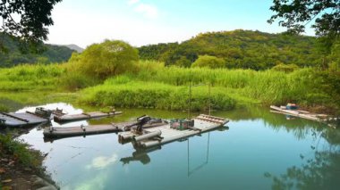 Gölde birkaç balıkçı teknesi ya da bambu salları var. Guangxing Wetland, New Taipei City 'de kuş izlemek için harika bir yer..
