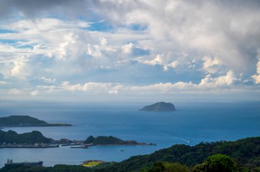 Mavi deniz, mavi gökyüzü ve dinamik beyaz bulutlar. Jiufen, New Taipei City, Tayvan 'dan Keelung Adası manzarası.