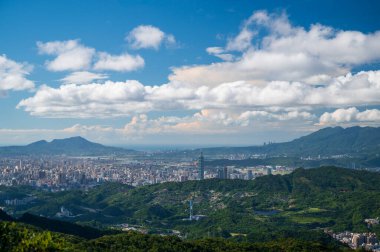 Güzel beyaz bulutlar dağların ve binaların üzerinden hızla geçiyor. Erge Dağı 'ndan gün boyunca Taipei şehrinin manzarası.