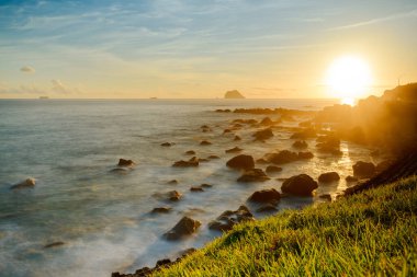 Rising Sun 's Radiance: Beachside Sunrise ve Rocky Serenity. Sabahın erken saatlerinde Keelung Adası 'nın güneşin doğuşunun tadını çıkar..