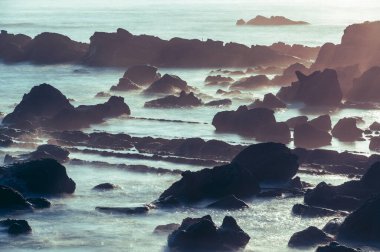 Sahil Gündoğumu Sihri: Deniz kenarındaki kayaları aydınlatan güneş ışığı. Sabahın erken saatlerinde Keelung Adası 'nın güneşin doğuşunun tadını çıkar..