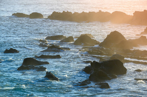 Прибрежная магия восхода солнца: солнечный свет, освещающий прибрежные скалы. Наслаждайтесь видом на восход солнца на острове Кейптаун ранним утром.