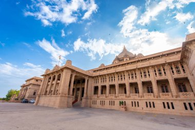 Otelin dışında yeşil çimenler, bahçeler ve küçük bir çeşme var. Taj Umaid Bhawan Sarayı, Jaisalmer, Rajasthan, Hindistan.