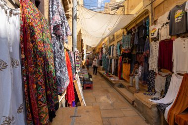 Jaisalmer, Rajasthan, Hindistan. 21 Eylül 2023: Jaisalmer Kalesi veya Sonar Quila. Geleneksel el yapımı duvar yaması ve giysi satan bir sokak..