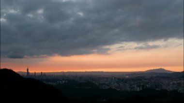 Sakin günbatımı tonlarında, Taipei ufuk çizgisinin çarpıcı manzarası ikonik Taipei 101 kulesi tarafından vurgulanır. Xizhi Dajianshan, Tayvan.