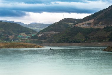 Güneş batar ve dağlar Yangtze Nehri 'nin etrafını sarar. Su koyu mavi ve gökyüzü rengarenk. Dağ suya yansıyor..