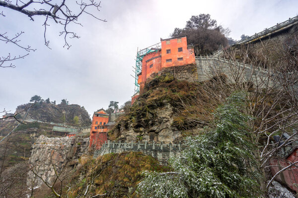 Ancient buildings in China's Wudang Mountains are elegantly decorated with a layer of snow, presenting a harmonious blend of nature and architecture.