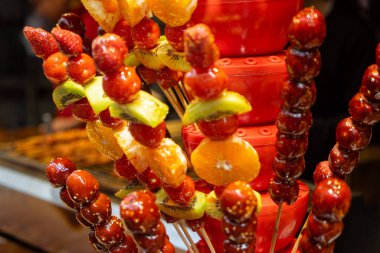 Wuchang, Çin 'de popüler bir sokak yemeği olan taze ve pürüzsüz meyve şişleri. Bu resim dokunun ve rengin zenginliğini yakalar.