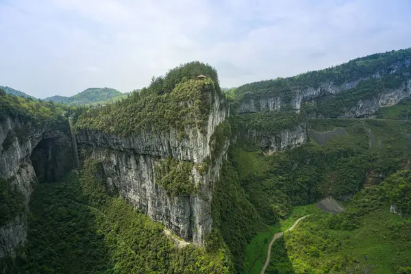 Dağın tepesinde bir pavyon var, vadide yürüyen bir patika. Üç Doğal Köprü doğal kireçtaşı köprüler serisidir, Chongqing..