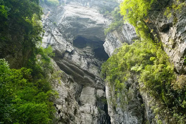 There are two round holes on the karst mountain wall that look like eyes. The Three Natural Bridges are a series of natural limestone bridges, Chongqing.