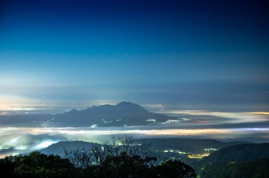 Bulutlar ve sis şehrin üzerinde sürükleniyor ve renkli parlak ışık parlıyor. Günbatımının ve bulutların tadını çıkar. Zhongzhengshan Yürüyüş Yolu, Taipei Şehri.