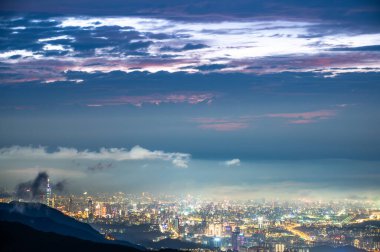 Yuvarlanan bulutlar ve şehir ışıkları gece manzarasını zenginleştiriyor. Dağdan Taipei şehrinin gece manzarasının tadını çıkarın. Tayvan