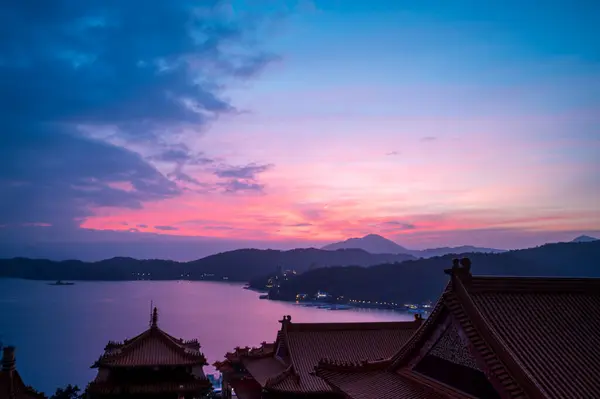 At dusk, the lake and mountains are beautiful, and the temple is silhouetted. Sun Moon Lake is one of Taiwan\'s famous tourist attractions. Nantou county.