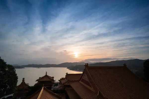 At dusk, the lake and mountains are beautiful, and the temple is silhouetted. Sun Moon Lake is one of Taiwan's famous tourist attractions. Nantou county.