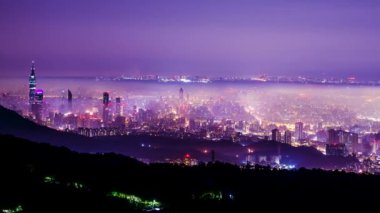 Taipei şehrinde beyaz bulutlar ve sis tabakası, şehir ışıklarıyla birlikte, renkli bir ışık oluşturur..