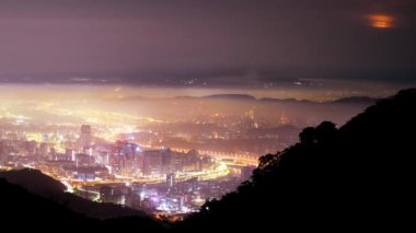 Taipei şehrinde beyaz bulutlar ve sis tabakası, şehir ışıklarıyla birlikte, renkli bir ışık oluşturur..