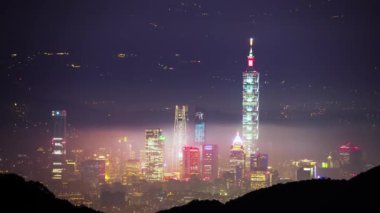 Taipei şehrinde beyaz bulutlar ve sis tabakası, şehir ışıklarıyla birlikte, renkli bir ışık oluşturur..