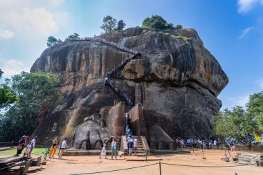 Dambulla, Sri Lanka - 26 Ocak 2024: Turistler Sigirya Kayası 'nın tepesine tırmanmaya hazırlanıyor, korkuluklara tutunarak, bölgenin panoramik manzarasıyla.
