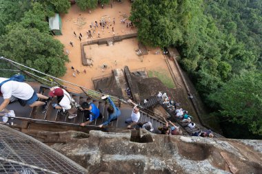 Dambulla, Sri Lanka - 26 Ocak 2024: Sigiriya Kayası 'nın tepesinden kuş bakışı görüş, merdivenlerden çıkan turistleri yakalamak ve diğerlerinin yer meydanında fotoğraf çekmesi.