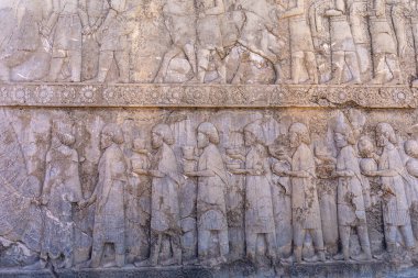 İnsanları ve hayvanları hareket halindeyken gösteren detaylı taş oymaları. Antik sanat eserlerine bir bakış, karmaşık tasarımlar ve hikaye anlatımları, Persepolis, İran.