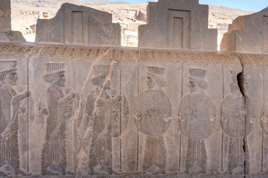 İnsanları ve hayvanları hareket halindeyken gösteren detaylı taş oymaları. Antik sanat eserlerine bir bakış, karmaşık tasarımlar ve hikaye anlatımları, Persepolis, İran.