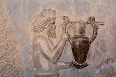 Asil bir şahsın süslenmiş bir gemiyle detaylı bir şekilde oyulması antik İran 'ın karmaşık sanatını gözler önüne seriyor. Yetenekli işçiliğin altını çiziyorum. Persepolis, İran.