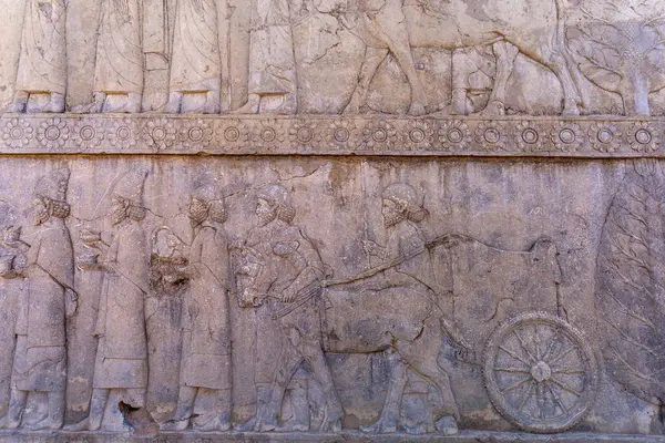 İnsanları ve hayvanları hareket halindeyken gösteren detaylı taş oymaları. Antik sanat eserlerine bir bakış, karmaşık tasarımlar ve hikaye anlatımları, Persepolis, İran.