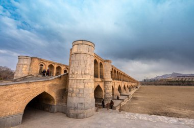 33 kemer köprüsü (Allah verdi Khan), İsfahan, İran - 4 Mart 2024: Yerel halk alacakaranlıkta geniş köprüde yürüyor ve dinleniyor. Köprü sakinleri için popüler bir buluşma yeridir..