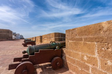 Bir dizi tarihi top, UNESCO Dünya Mirası Alanı olan Essaouira, Fas 'ın tahkimatları üzerine denize bakıyor. Açık mavi gökyüzü manzaraya güzellik katar..