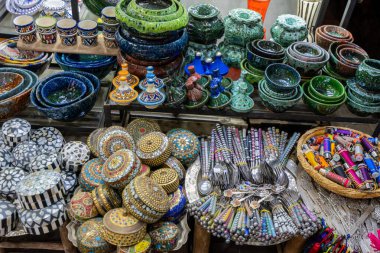 Jemaa el-Fnaa, Marakeş, Fas - 18 Mart 2024: Yerel pazarda seramik ve hasır şapkalar da dahil olmak üzere geleneksel Fas zanaatlarının canlı gösterisi.