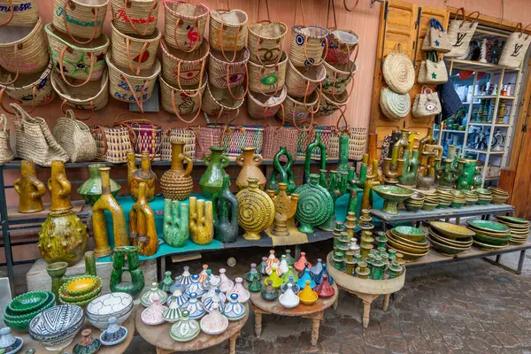 Jemaa el-Fnaa, Marakeş, Fas - 18 Mart 2024: Yerel pazarda seramik ve hasır şapkalar da dahil olmak üzere geleneksel Fas zanaatlarının canlı gösterisi.