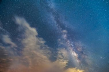 Gece yıldızlı gökyüzü. Samanyolu beyaz bulutlarla kaplanmak üzere. Zümrüt Rezervuar 'ı çevreleyen dağların manzarası. Xindian Bölgesi, Tayvan.