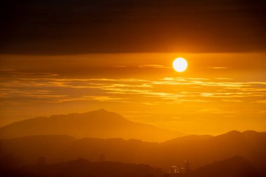 Gün batımında, güneş bulutlar arasında mekik dokuyor ve sonunda bulutlar tarafından engelleniyor. Dajianshan 'da alacakaranlık gökyüzünün manzarası. Xizhi Bölgesi, New Taipei, Tayvan.