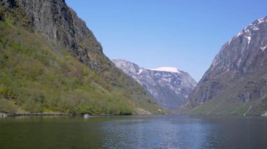 Yol boyunca karlı dağlar, şelaleler ve göl yansımaları var. Dünya Mirası Sognefjord 'u gezin ve güzel manzaranın tadını çıkarın. Norveç.