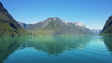 Yol boyunca karlı dağlar, şelaleler ve göl yansımaları var. Dünya Mirası Sognefjord 'u gezin ve güzel manzaranın tadını çıkarın. Norveç.