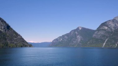 Yol boyunca karlı dağlar, şelaleler ve göl yansımaları var. Dünya Mirası Sognefjord 'u gezin ve güzel manzaranın tadını çıkarın. Norveç.