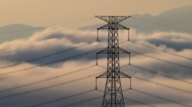 Yüksek voltajlı bir kule ve bir yaz sabahı tepetaklak düşen bulutlar denizi. Zümrüt Rezervuar 'ı çevreleyen dağların manzarası. Xindian Bölgesi, Tayvan.