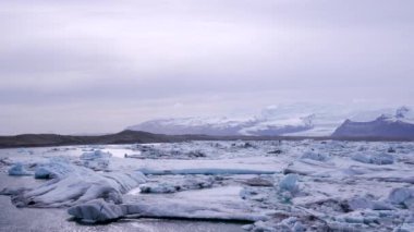 Mavi ve beyaz buzdağları buzul zeminine karşı buzul gölünde yüzerek huzur verici bir manzara yaratırlar. Bozulmamış Jokulsarlon, İzlanda.
