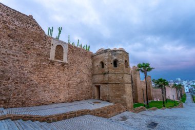 Beyaz binaları ve engin genişliğiyle Udayas Kasbah 'ı. Kalın bulutlar arasında ara sıra güneş ışığı. Günbatımı manzarası için harika bir yer. Rabat, Fas.