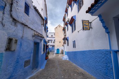 Dar sokağın duvarında eski bir otel tabelası asılı. Fas. Mavi ve beyaz tonlu evler rüya gibi ve büyüleyici. Şef! Şef!.