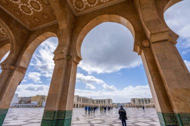 Kazablanka, Fas - 26 Mart 2024 Hassan II Camii 'nden ayrılan ve geniş meydandan geçen ziyaretçiler.