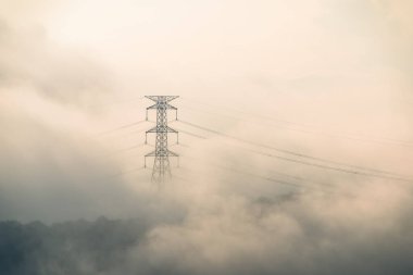 Yüksek voltajlı bir kule ve bir yaz sabahı tepetaklak düşen bulutlar denizi. Zümrüt Rezervuar 'ı çevreleyen dağların manzarası. Xindian Bölgesi, Tayvan.