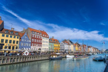 Kopenhag, Danimarka - 29 Nisan 2024: Vibrant Nyhavn rıhtımı renkli 17. yüzyıl evleri ve kanallarıyla kaplı.