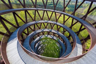 Gisselfeld Klosters Skove, Danimarka - 29 Nisan 2024: Bereketli yeşilliğin ortasındaki sarmal ahşap ağaç tepesi geçidi.