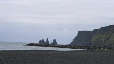 Kara Kum Sahili dünyanın en güzel on plajından biri olarak seçildi. Reynisdrangar kaya oluşumlu siyah kumsal. Volkanik kum, Vik, İzlanda.
