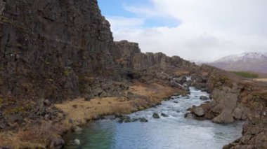 Dünyanın tektonik gücünü gösteren sakin bir dere Thingvellir Ulusal Parkı 'nın muhteşem yarık vadisinde dolanıyor. Jeolojik harikalar, İzlanda.